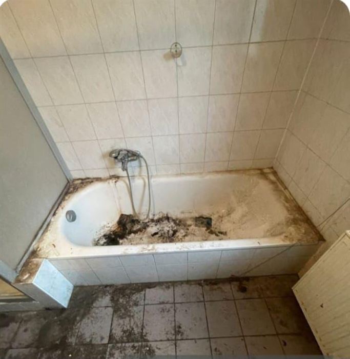 Badewanne vor der Reinigung, stark verschmutzt, mit dunklen Ablagerungen im Becken und an den Fliesenrändern