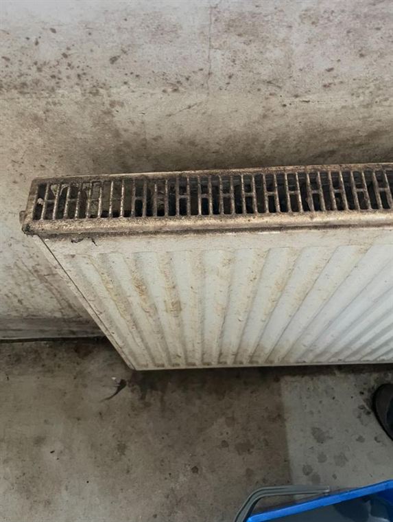 Stark verstaubter Heizkörper mit Flugrost und Ablagerungen im oberen Abdeckgitter