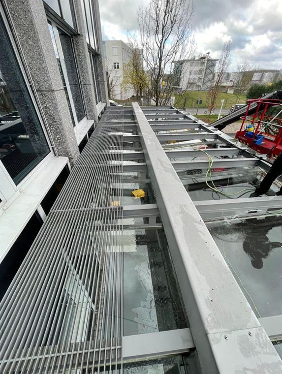 Dasselbe Glasvordach nach der Reinigung: helle Träger und klare Glasflächen