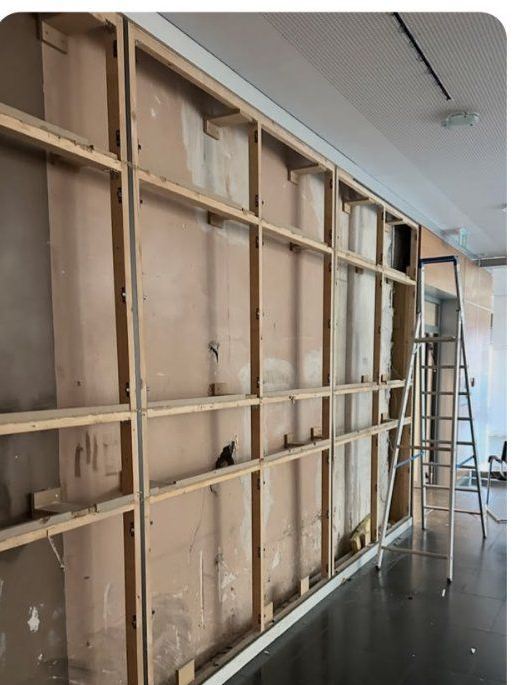 Bürowand, bis auf das hölzerne Ständerwerk zurückgebaut, daneben eine Leiter