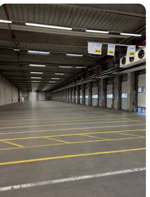 Große leere Logistikhalle mit Verladetoren nach dem Rückbau der Einbauten